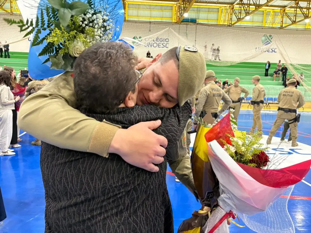 Novo soldado temporário abraça familiar após a formatura no 26º BPM, em Herval d’Oeste
