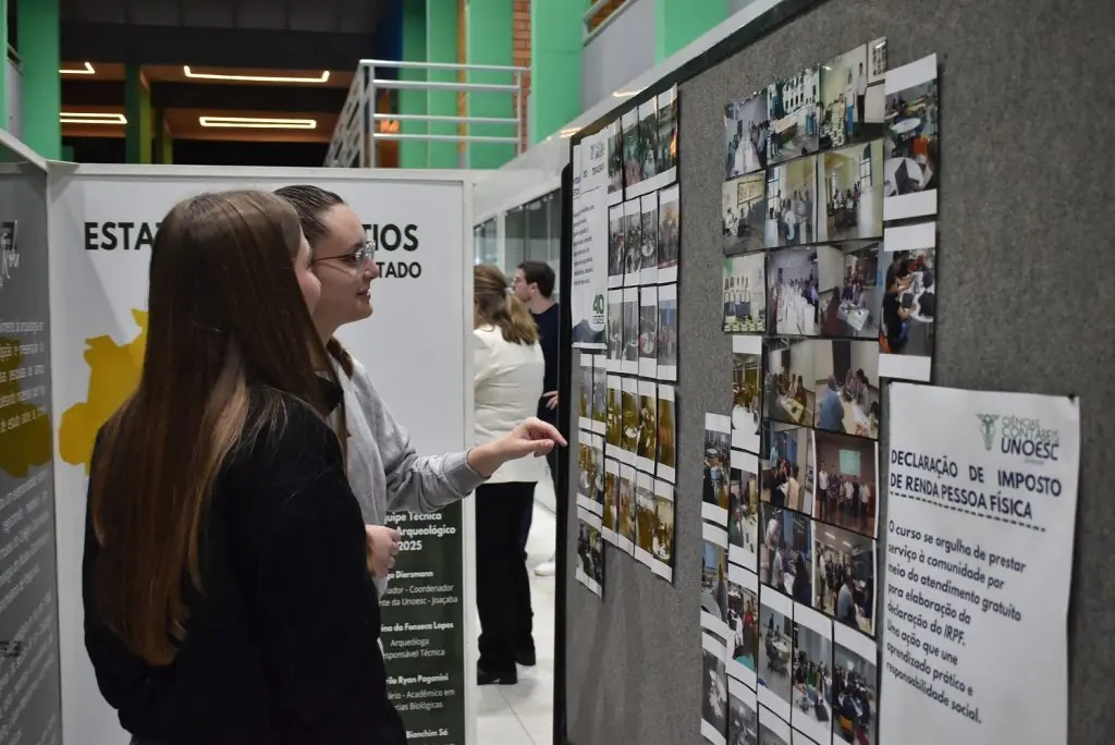 Visitantes observam painéis com fotografias da exposição dos 40 anos do curso de Ciências Contábeis da Unoesc Joaçaba, no Museu do Centro Arqueológico