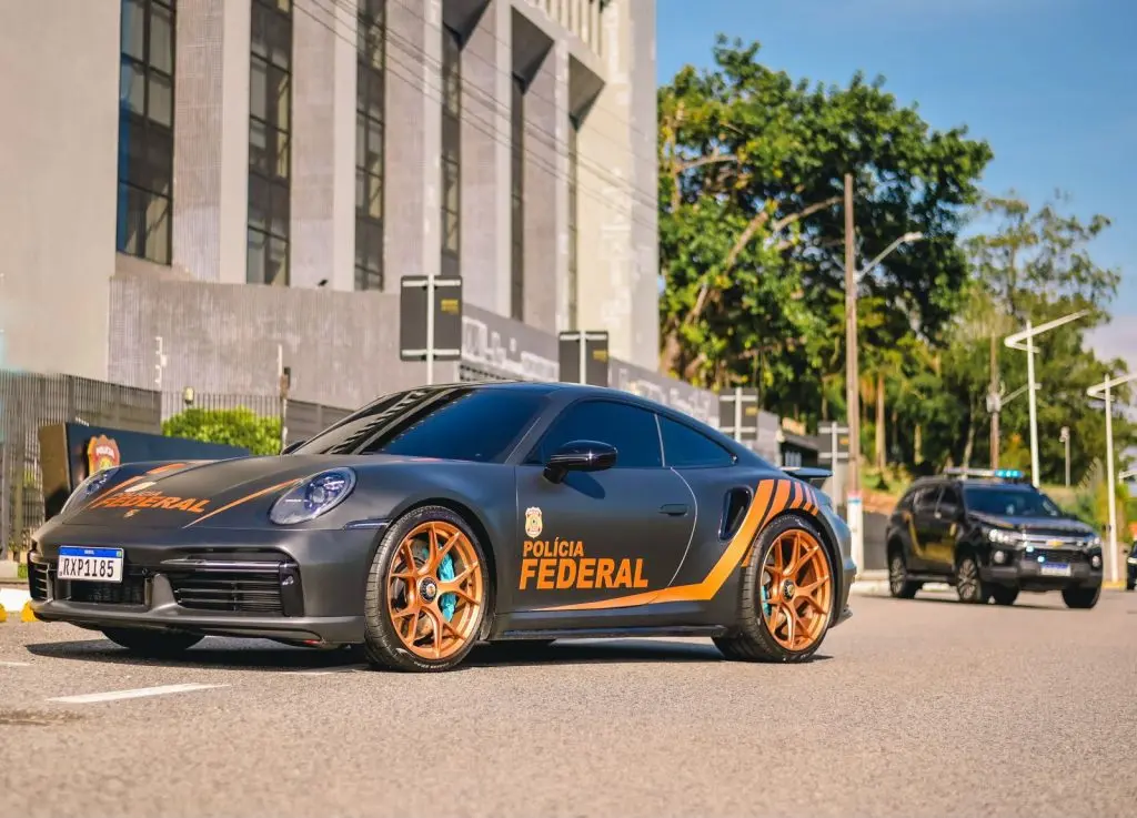 Porsche 911 Turbo da Polícia Federal estacionado em frente a prédio, com viatura ao fundo