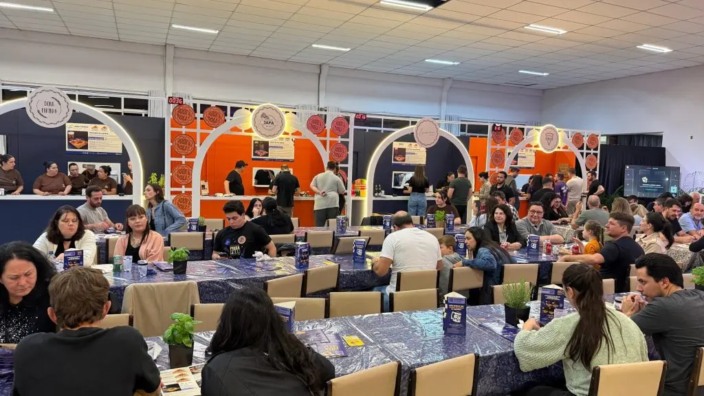 Estandes das pizzarias e mesas com público no Pizza & Fuzz