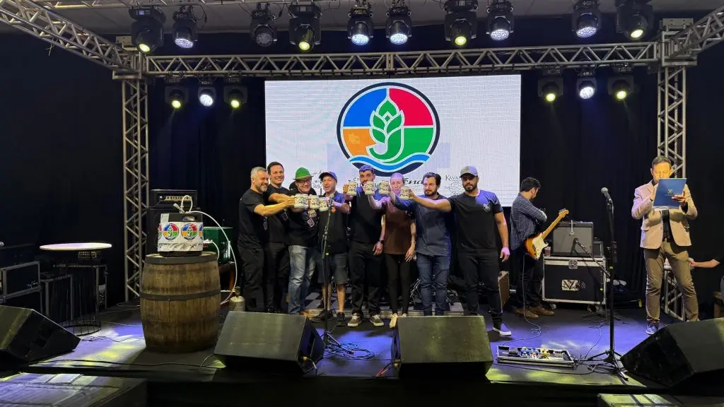 Autoridades e organizadores brindam com canecos no palco do Pizza & Fuzz