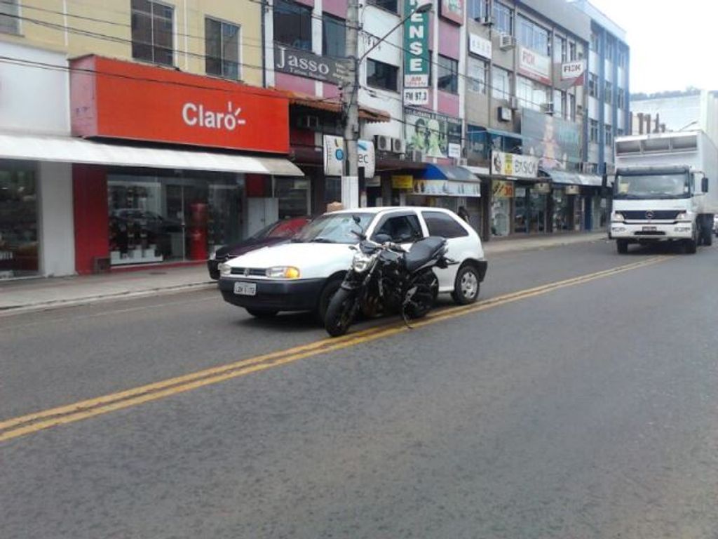 Acidente no centro deixa motocicleta presa em veículo