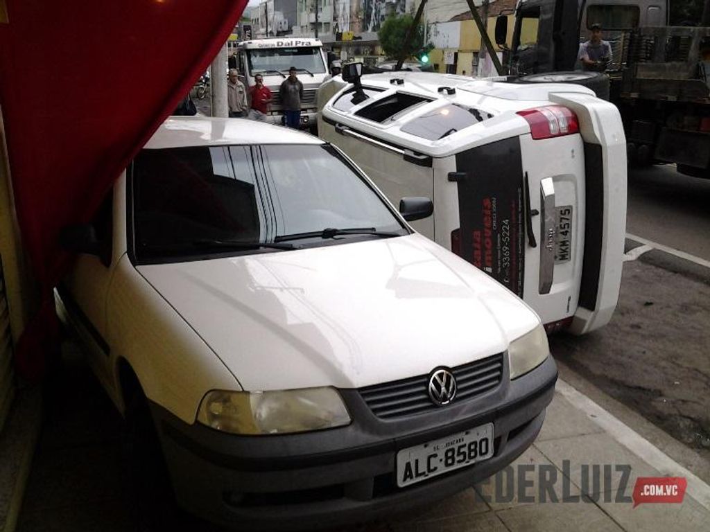 Caminhonete capota no centro e atinge carro estacionado que quasa vai parar dentro de loja