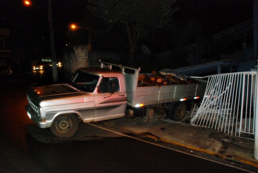 Motorista bate caminhonete contra garagem e carro estacionado